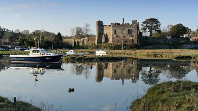 Laugharne Castle with a small boat in front